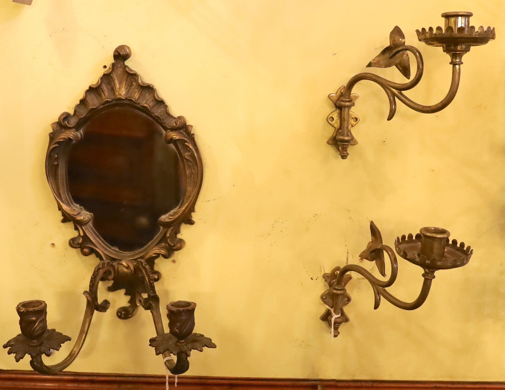 A pair of English Arts & Crafts brass candle sconces and a bronze girandole, height 18cm and 35cm